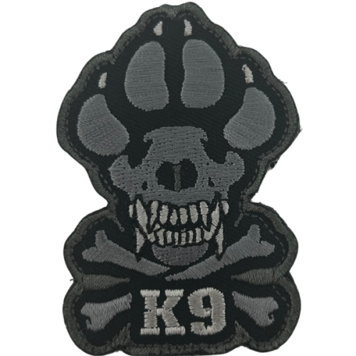 A woven velcro patch with a crossbones and the paw of a working dog with "K9" embroidered on it.